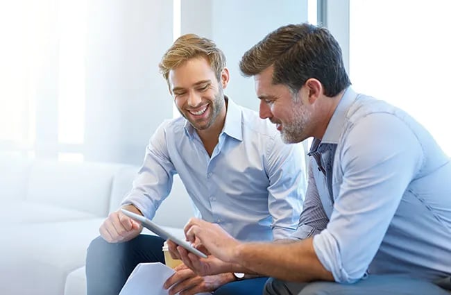 Two business casual professionals discussing around a Tablet device